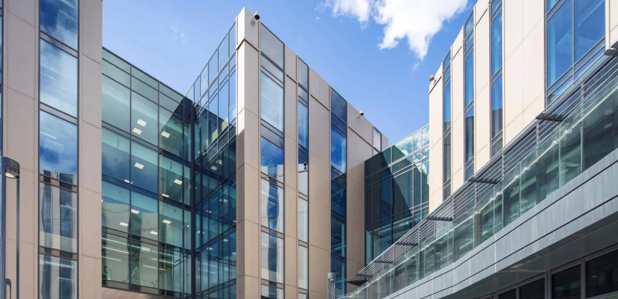 A large, multi-sided, glass-faced building