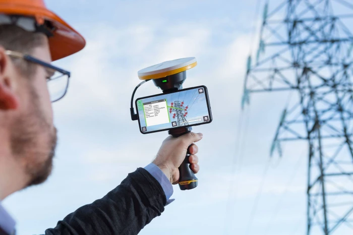 Someone in a hard hat and high-vis jacket inspecting a solar panel